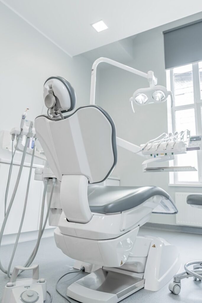 A white dental chair in a room with a window