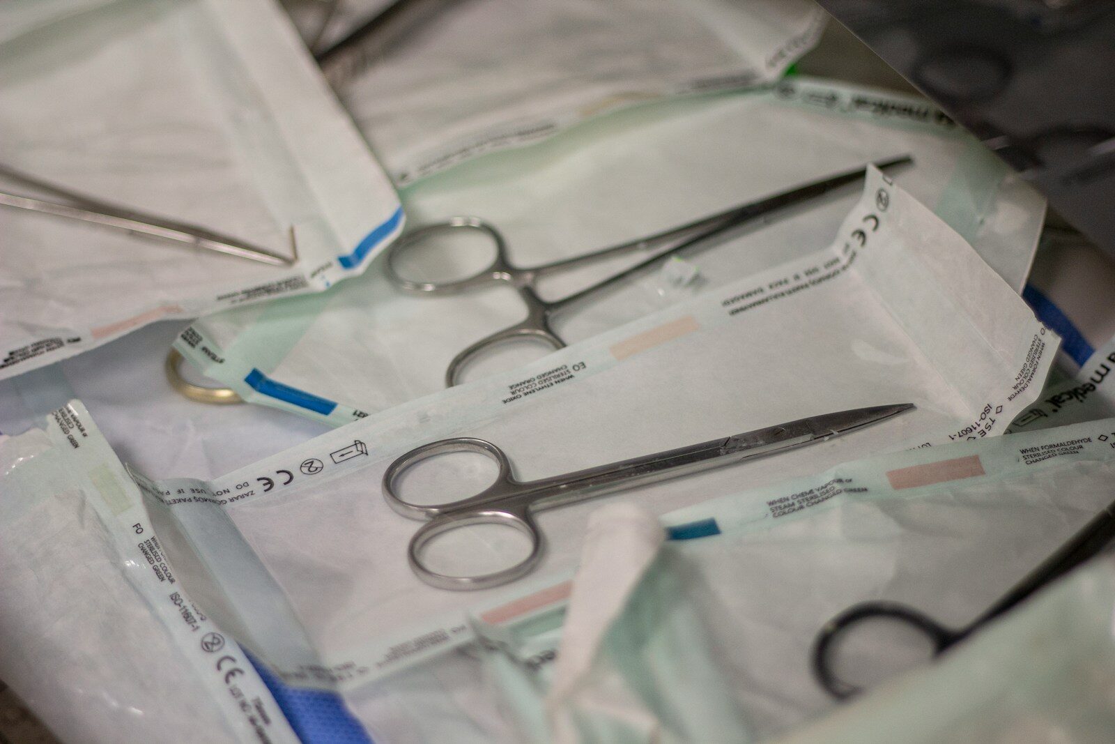 a pair of scissors sitting on top of a pile of medical supplies